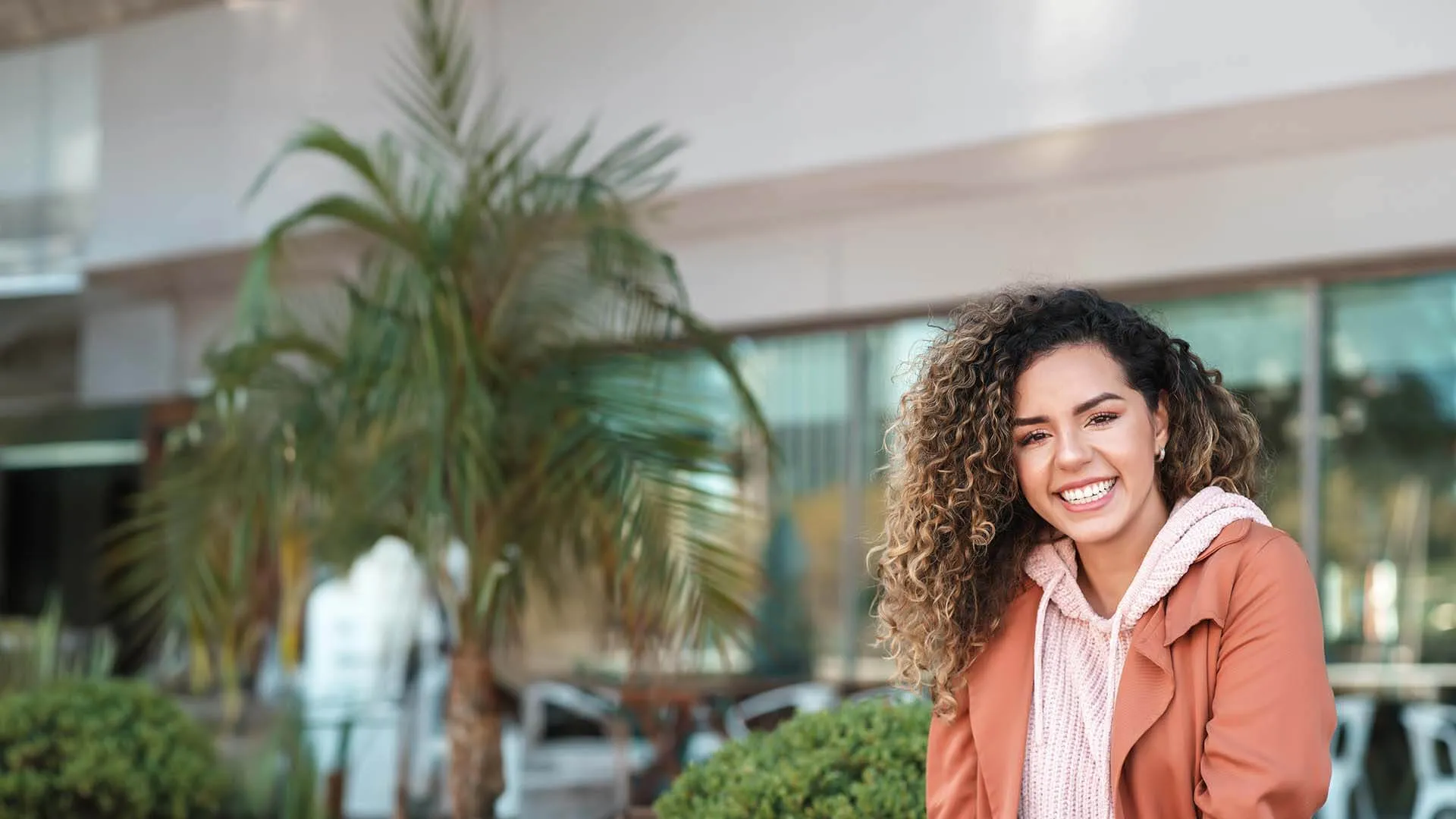 a woman smiling in front of a building