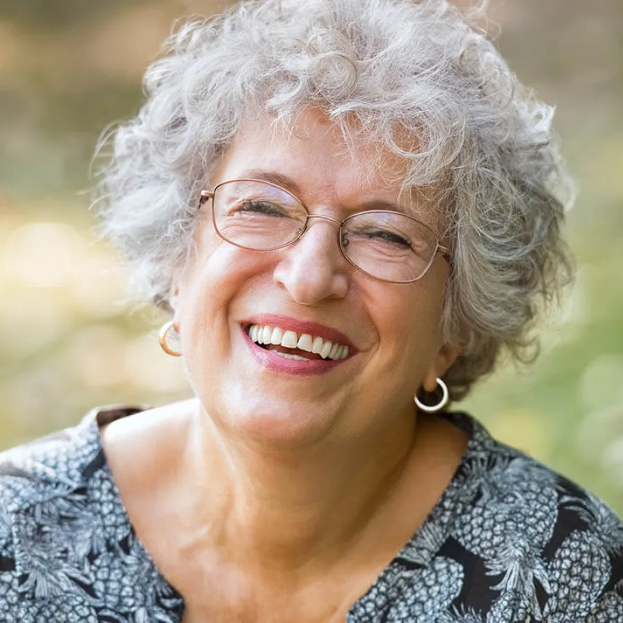 a person with glasses smiling